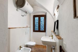 a white bathroom with a sink and a toilet at The Gallery - Unità 16 in Baiardo