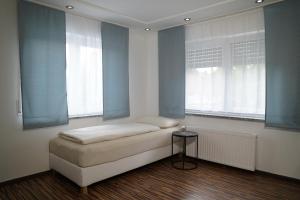 a bed in a room with two windows and a table at Dreams im Erdgeschoss in Koetz 