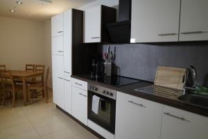 a kitchen with white cabinets and a stove top oven at Dreams im Erdgeschoss in Koetz 