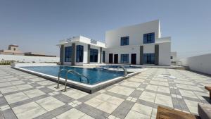 a house with a swimming pool in front of it at Al REEF in Billah +13 photos