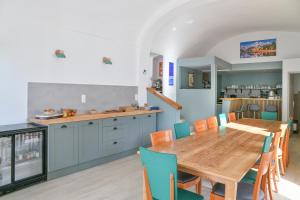 a kitchen and dining room with a wooden table and chairs at Chambres d'hôtes - Chez Antho in Betton-Bettonet