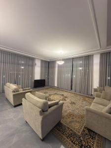 a large living room with couches and a rug at Al REEF in Billah