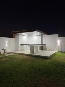 a white building with a table in a yard at night at Al REEF in Billah