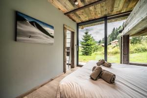 a bedroom with a bed with two towels on it at Chalet Bella in Essert-Romand