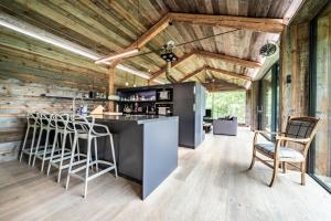 a kitchen with wooden walls and a bar with stools at Chalet Bella in Essert-Romand
