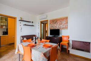a dining room with a table with orange chairs at Stella Maris a Porto Cesareo in Porto Cesareo