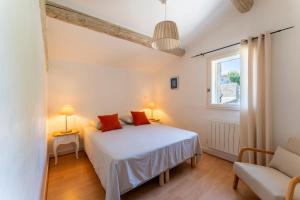 a bedroom with a white bed and a window at Mazet de Cabrières Gordes, Clim in Cabrières-dʼAvignon
