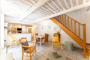 a living room with a staircase and a table and chairs at Mazet de Cabrières Gordes, Clim in Cabrières-dʼAvignon