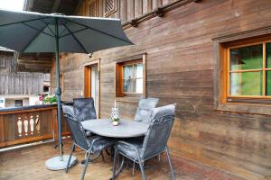 a table and chairs with an umbrella on a deck at Appartment Stockeben in Niederau