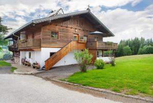 a large wooden house with a large deck at Appartment Stockeben in Niederau