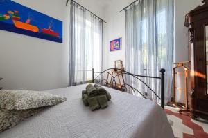 a stuffed elephant sitting on a bed in a bedroom at La Casa Bianca in Lipari