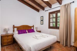 a bedroom with a large white bed and a window at Can Llobera in Pollença +23 photos