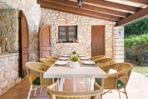 an outdoor dining room with a white table and chairs at Can Llobera in Pollença