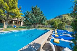 a pool with lounge chairs next to a house at Can Llobera in Pollença