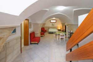 a room with a bed and a table and chairs at Casa dell'Angelo in Muro Leccese