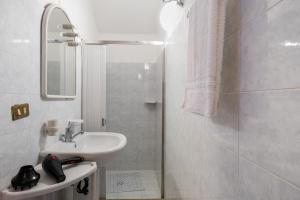 a white bathroom with a sink and a shower at Casa dell'Angelo in Muro Leccese