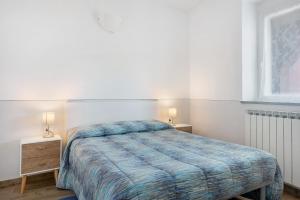 a bedroom with a bed with a blue comforter at Casa mare montaretto 2 in Bonassola
