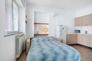 a small bedroom with a bed and a kitchen at Casa mare montaretto 2 in Bonassola