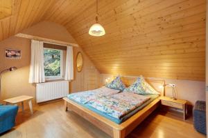 a bedroom with a bed in a wooden room at Grundhof in Oberprechtal