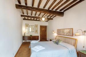 a bedroom with a white bed and a wooden ceiling at Il Tuo Posto A Greve In Chianti in Greve in Chianti