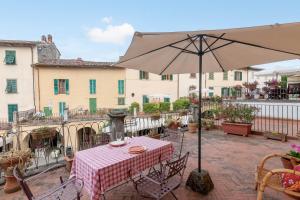 a patio with a table and an umbrella at Il Tuo Posto A Greve In Chianti in Greve in Chianti