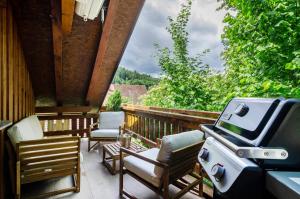 a patio with chairs and a grill on a porch at Enjoy mal - Apartments in Stockach