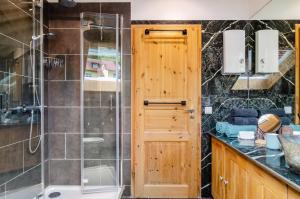 a bathroom with a shower and a wooden door at Enjoy mal - Apartments in Stockach +22 photos