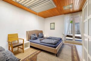 a bedroom with a bed and a chair at Balingen Apartment in Balingen