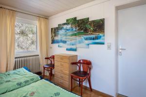 a bedroom with two chairs and a bed and a dresser at Villa Sonnenwinkel in Todtmoos +49 photos