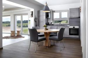 a kitchen and dining room with a wooden table and chairs at Panorama in Ibach