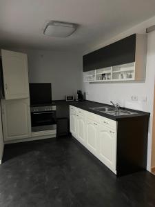 a kitchen with white cabinets and a sink at Ferienwohnung Arnstadt Ost in Arnstadt