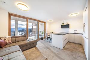 a living room with a couch and a kitchen at Apartment Klara in Meltina