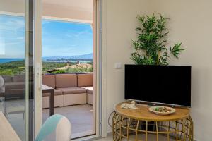 a living room with a tv and a table with a television at Villa Leone con piscina privata in Punta Molara
