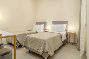 two beds in a room with two tables and two lamps at Villa Leone con piscina privata in Punta Molara +23 photos