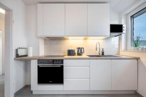 a white kitchen with a stove and a sink at Kroge Apartment in Uelzen