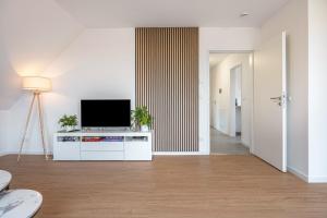 a living room with a flat screen tv on a cabinet at Kroge Apartment in Uelzen