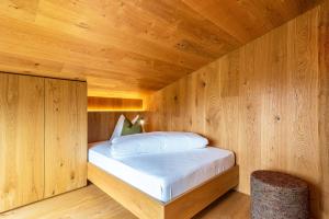 a bedroom with a bed in a wooden room at Chalet Bergfreund in Valdaora