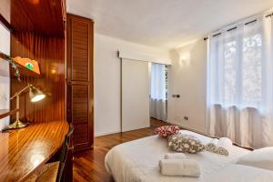 a bedroom with a bed and a desk and a window at la vigna del Vescovo in Verona