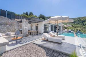a villa with a swimming pool and a house at Nimbus Villas in Kalamitsi