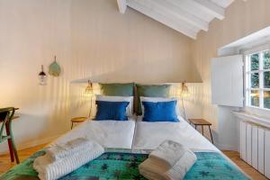 a bedroom with a large bed with blue pillows at Casa de São Pedro Sintra in Sintra