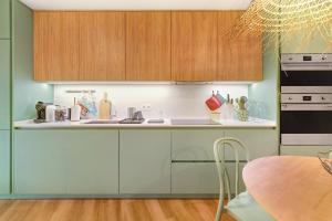 a kitchen with green cabinets and a sink and a table at Casa de São Pedro Sintra in Sintra