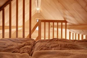 a bed in a room with a wooden ceiling at Schwarzwaldchalet Holzperle in Lenzkirch