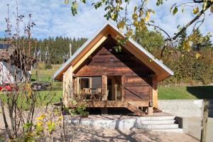 a small log cabin with a porch and stairs at Schwarzwaldchalet Holzperle in Lenzkirch