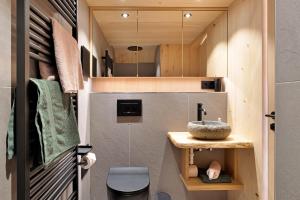 a small bathroom with a sink in a tiny house at Schwarzwaldchalet Holzperle in Lenzkirch +22 photos