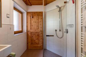 a bathroom with a shower and a wooden door at Malsötscherhof Apt C in Villandro +22 photos