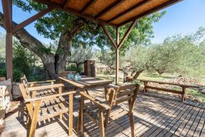 a wooden deck with a table and chairs under a tree at Casa Arbol in Camarles