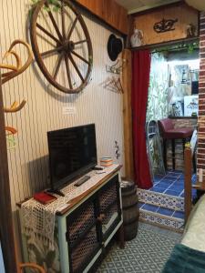 a room with a tv and a wheel on the wall at Room - Les loups bleus in Rossillon