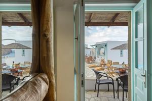 a room with a view of a patio with chairs and tables at Santanna Suites in Patmos
