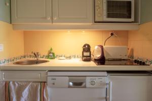a kitchen counter with a sink and a microwave at Restanques de Saint Tropez - arums in Grimaud +17 photos