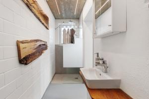 a white bathroom with a sink and a mirror at Ferienwohnung Atelier in Schopfheim +25 photos